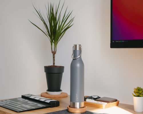 A tranquil view of a domestic home office setting with a clear water bottle on the desk